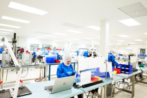 workers in sterile garb lab manufacturing medical devices