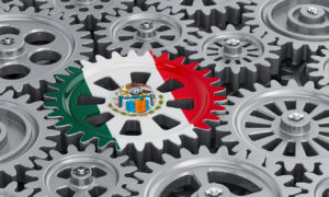 Mexican flag on the gearwheel, business industrial concept. 3D rendering