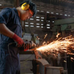 man in warehouse grinding metal