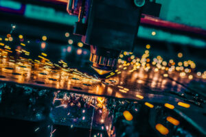 CNC Laser cutting of metal close up, modern electronics manufacturing. Small depth of field.