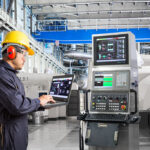 Engineer using laptop computer for maintenance equipment in factory