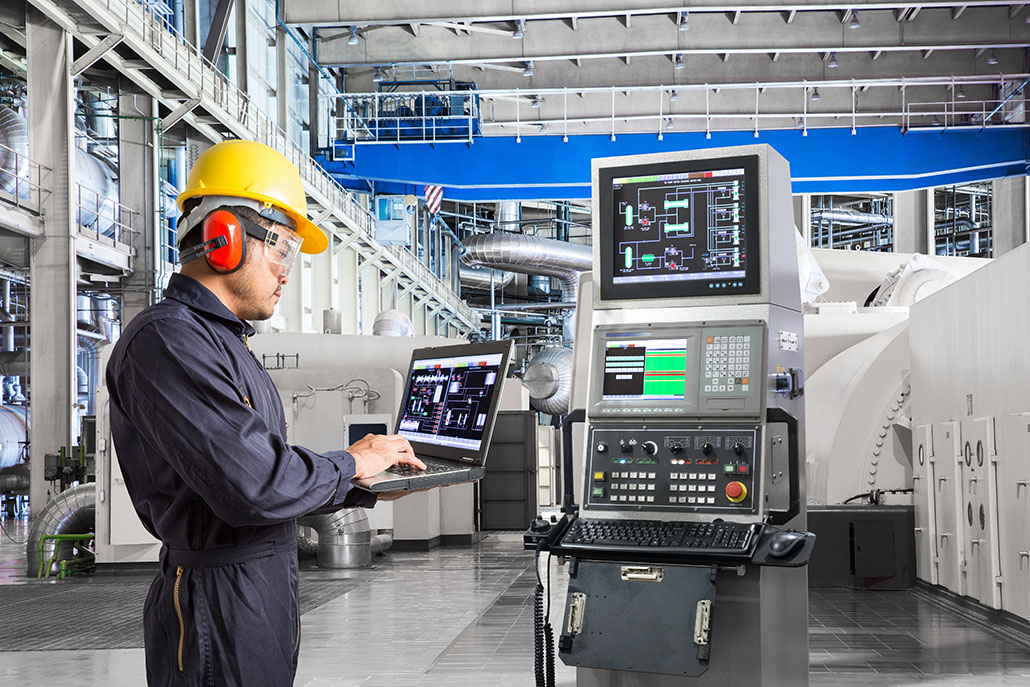 Engineer using laptop computer for maintenance equipment in factory